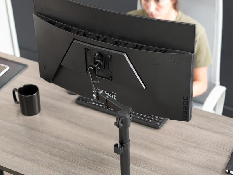 Side view of Orgemy monitor stand showing C-Clamp attachment to desk edge.