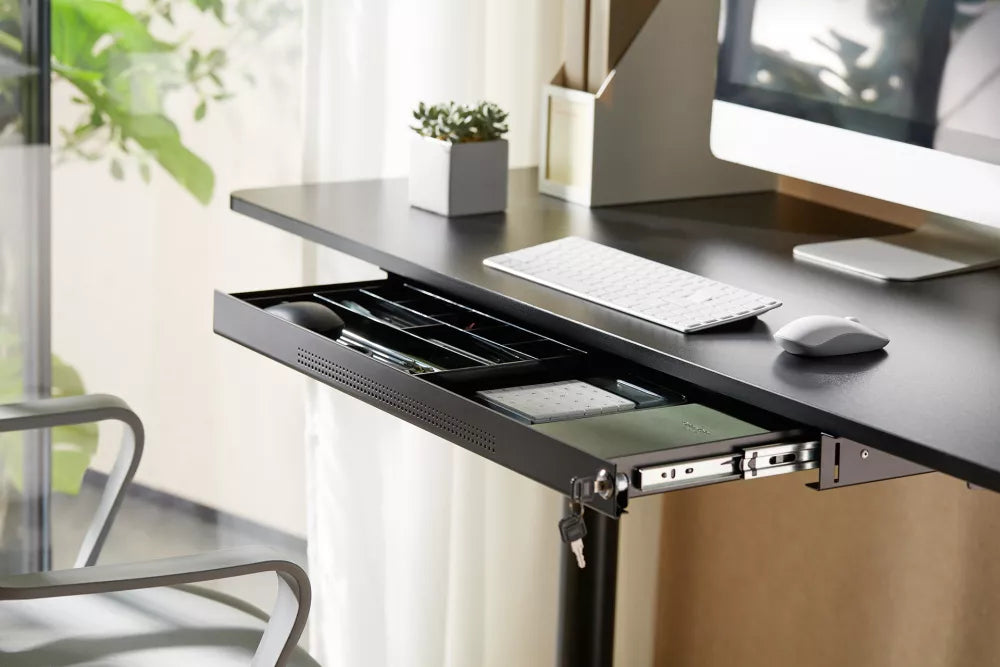 Orgemy wide 29 inch under desk drawer installed on a black office desk holding stationery.