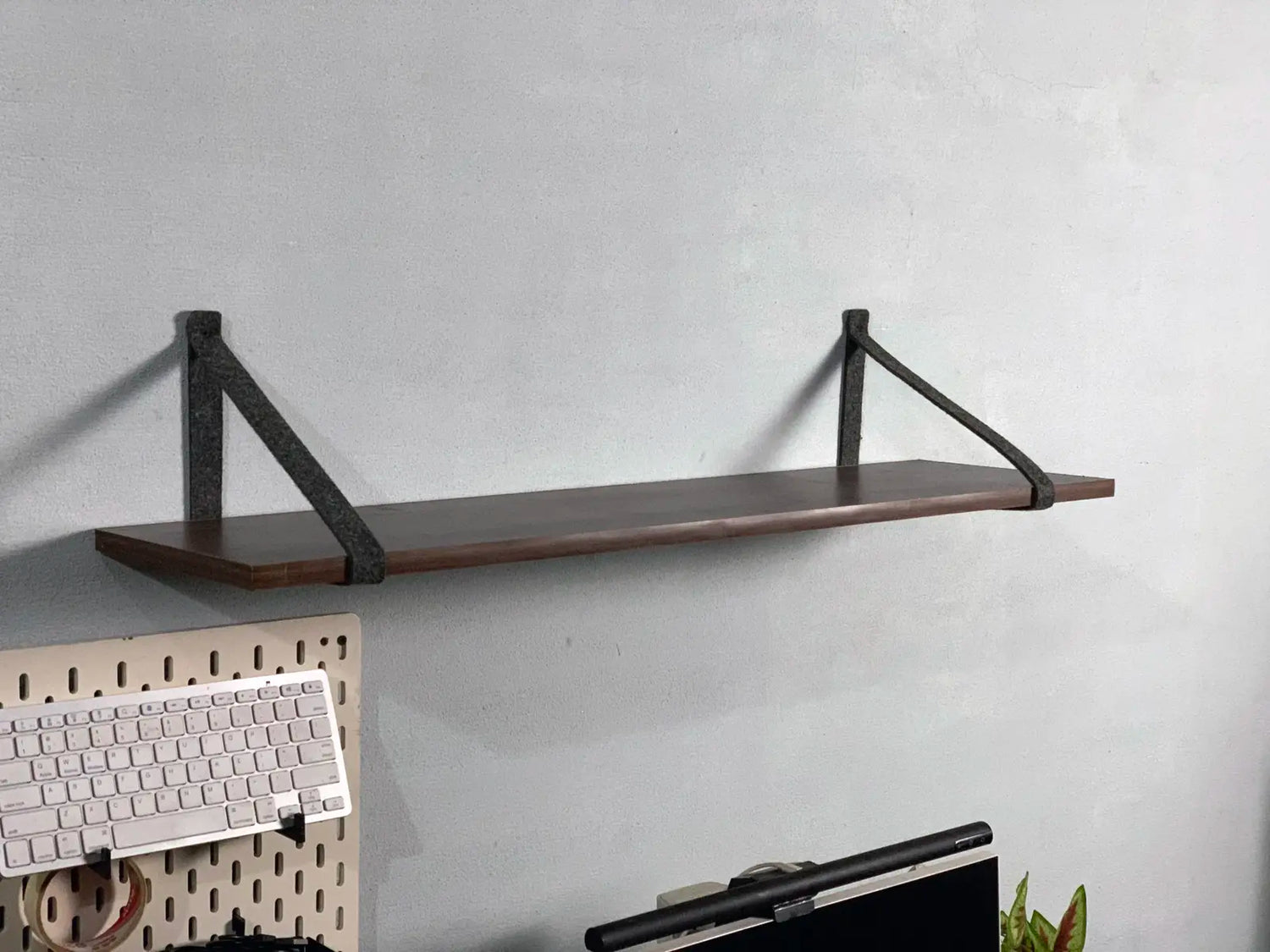 Side view of felt shelf holder showing minimalist mounting style.